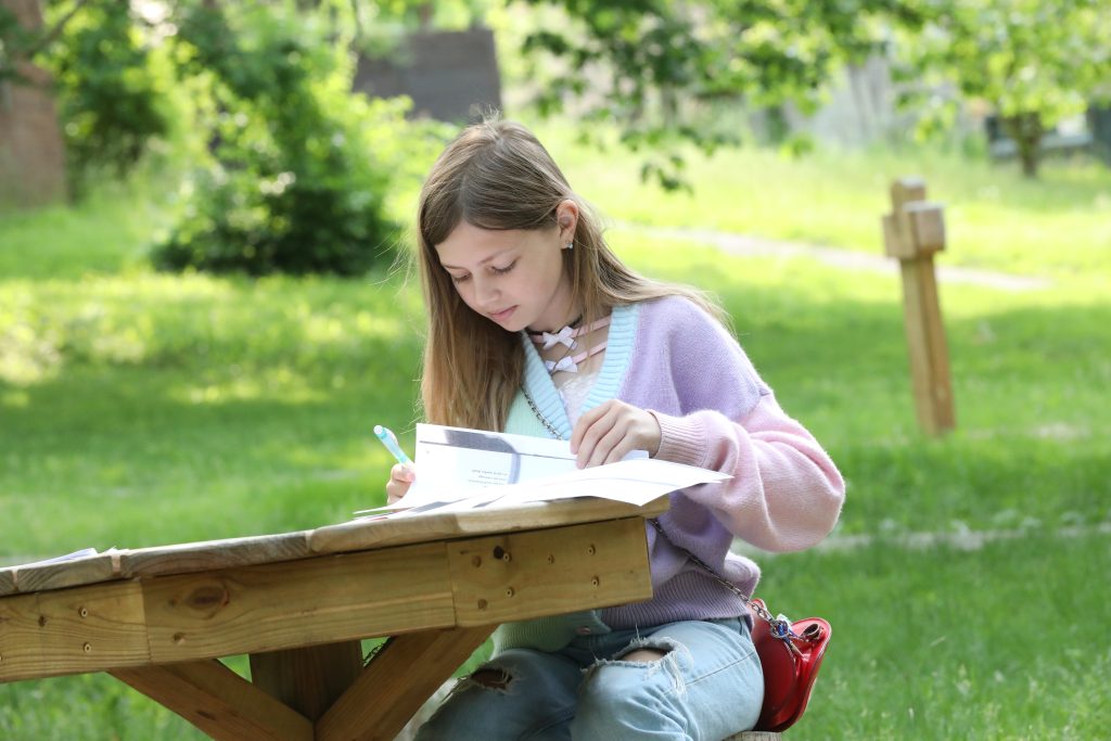 a middle school girl doing an assignment outside at Oakwood Friends School