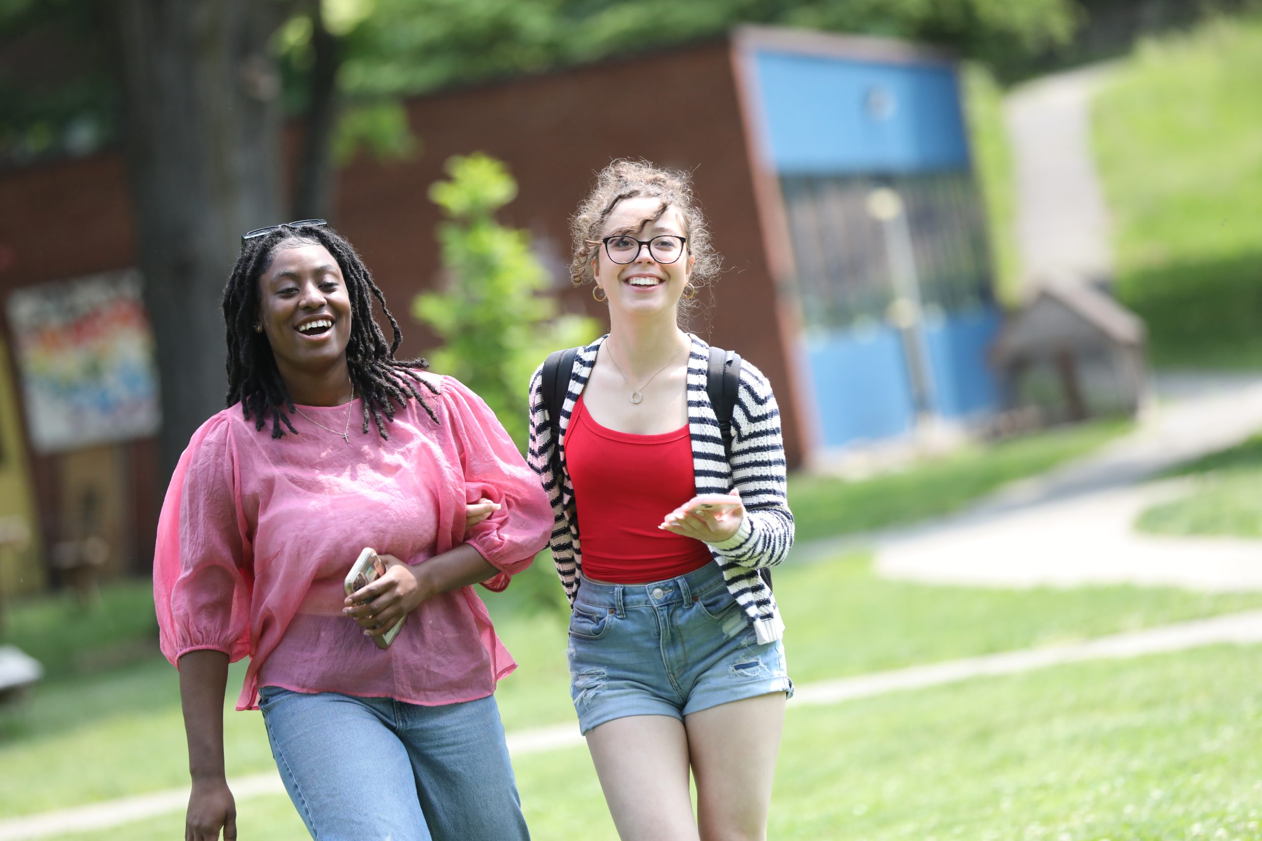 Two female students enjoy a sunny day on the quad
