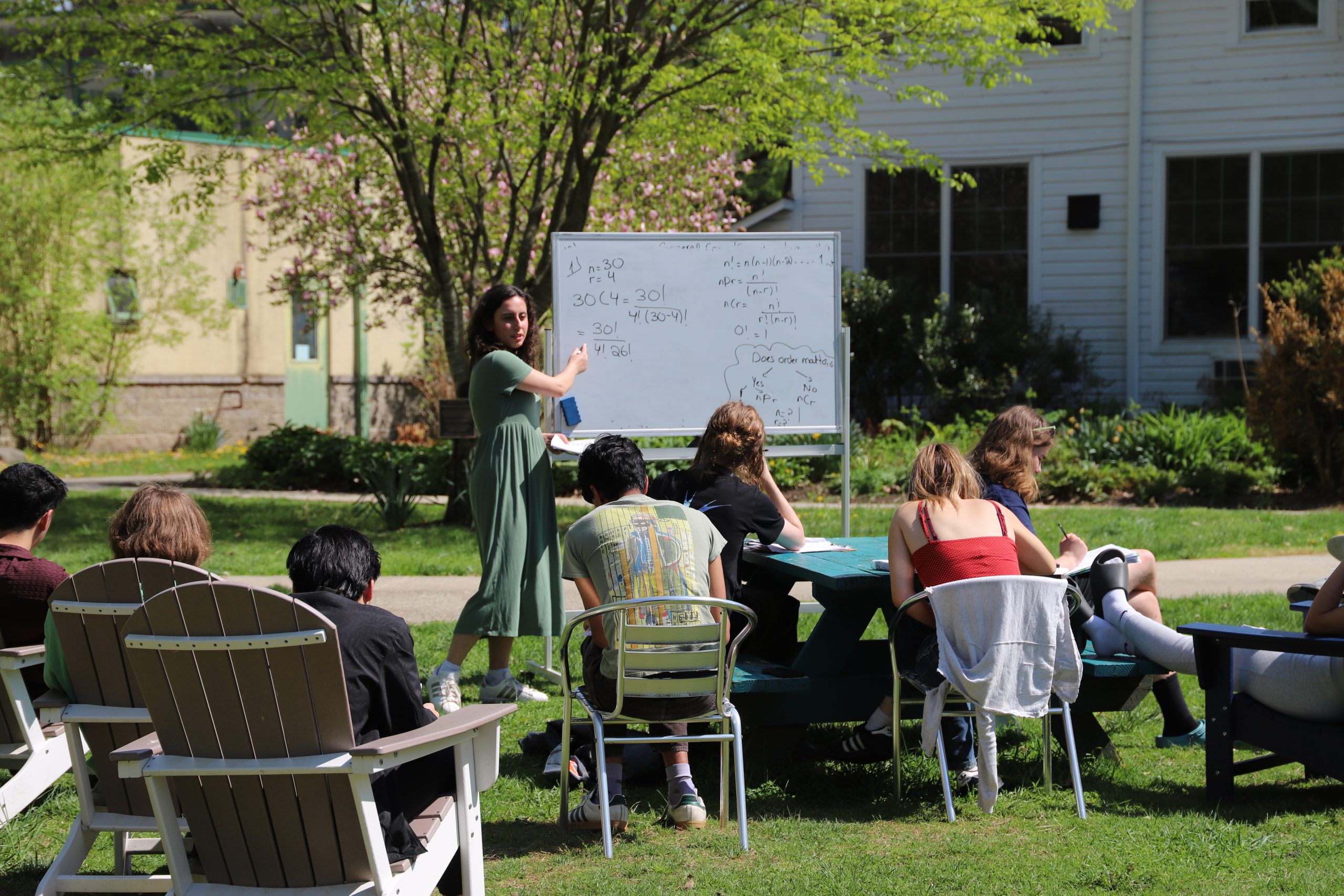 A teacher and her class learn math outside on a sunny day at Oakwood Friends School