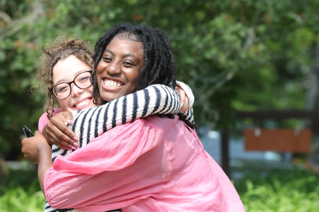 Two female upper school students embracing each other